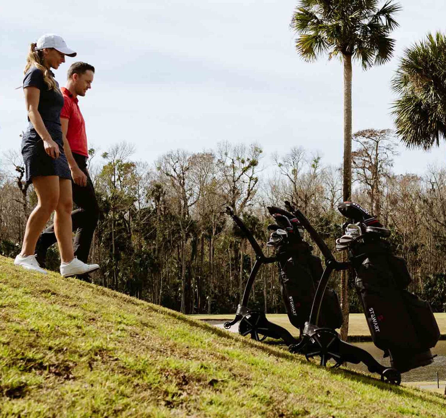 Couple walking down slope with their Apex trolleys