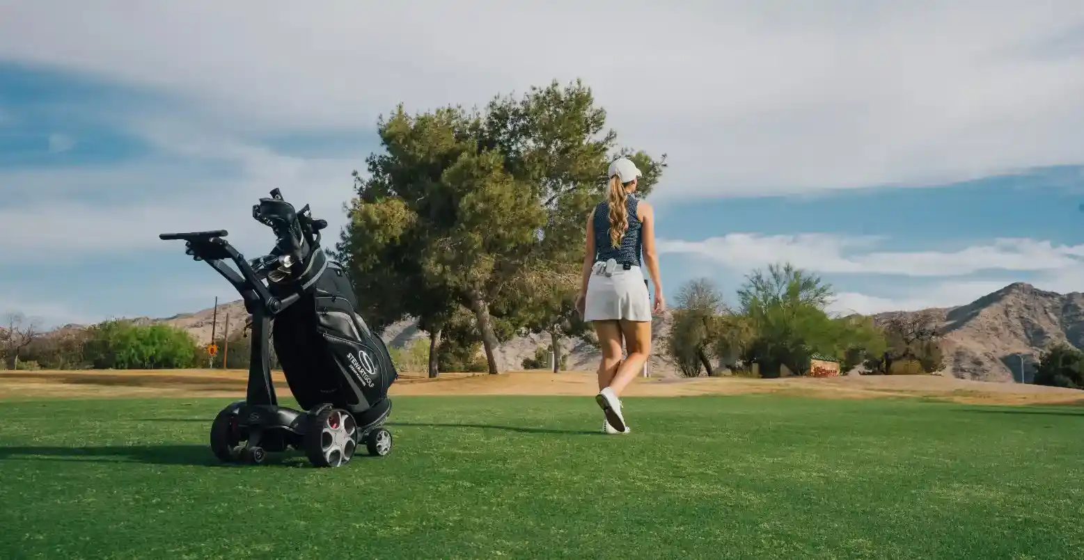 Hannah walking down the fairway with Q Follow caddie